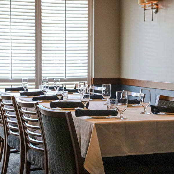 Waypoint Seafood & Grill dining room with set tables, chairs, and window blinds.