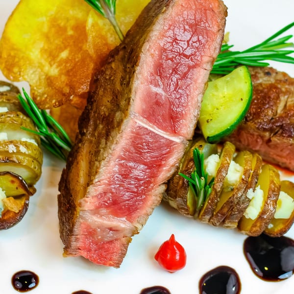 Waypoint Seafood & Grill's perfectly cooked steak, served with crispy potatoes, zucchini, and rosemary.